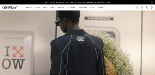 Shopify stores: A person wearing sunglasses and a black Off-White jacket stands in front of a subway door, partially blocking a sign, with a bouquet of white flowers visible behind them.